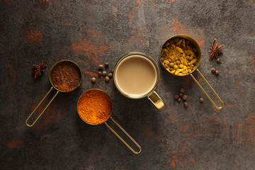 Masala tea and spices on dark gray background, top view