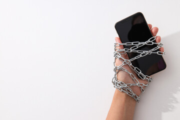 Fototapeta na wymiar The smartphone is encased in a chain with a lock