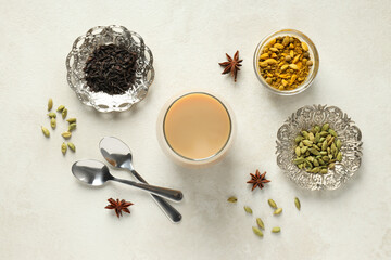 Masala tea, spices and spoons on light background, top view