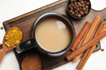 Masala tea and spices on wooden board on white background, top view