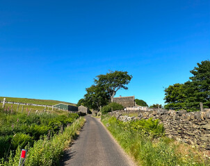 Country landscape near, Beeston Hurst, with wild flowers, dry stone walls, fields, and a blue sky in, Ripponden, UK