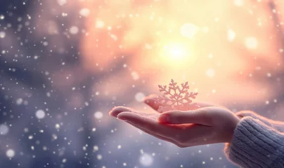 Fotobehang Female hands with sparkling wonderful snowflake or ball on a white snow background. Winter and Christmas concept. Magical fairy tale landscape copy space © annebel146