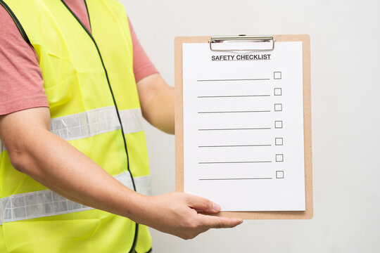 Staff holding blank checking on safety checklist form. Hand of staff is using the safety checklist sheet to verify working condition in isolated background.