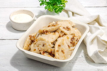Dumplings, filled with cabbage. Fried onion, fresh sour cream. Traditional Ukrainian dish