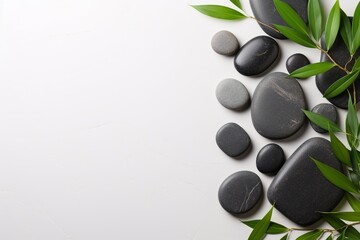 Obraz na płótnie Canvas A serene flat lay presenting hot stones and bamboo, exuding a calming and peaceful ambiance, with a considerate amount of empty space for versatile use in wellness and spa contexts.