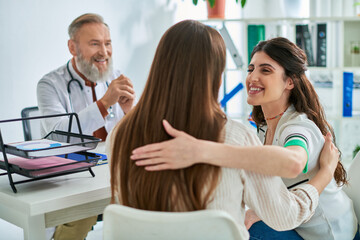 Fototapeta premium happy lesbian couple smiling and hugging each other after doctor told them news, ivf concept