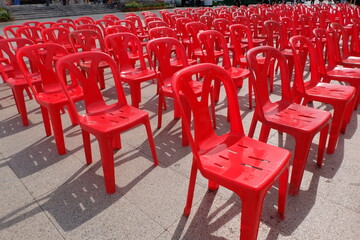 Red chairs for attendees of meetings, seminars, and recreational activities. Arrange them in rows in an outdoor location.