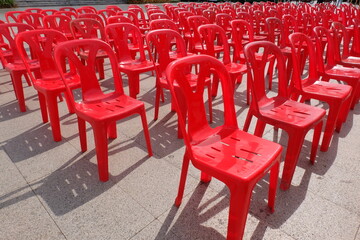 Red chairs for attendees of meetings, seminars, and recreational activities. Arrange them in rows in an outdoor location.