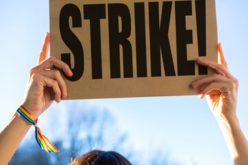A female activist holding a sign with the slogan of the hollywood actors and writers strike with...