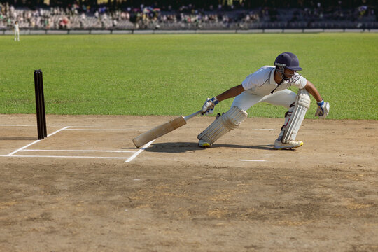 Batsman taking a run during a cricket match