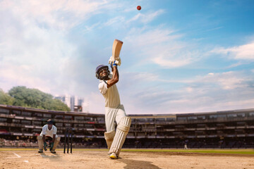 low angle shot of a Cricketer batsman hitting a lofted shot during a cricket match 