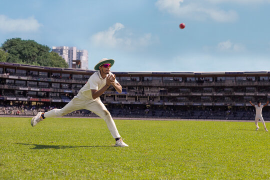 A fielder about to catch the  ball during a cricket match