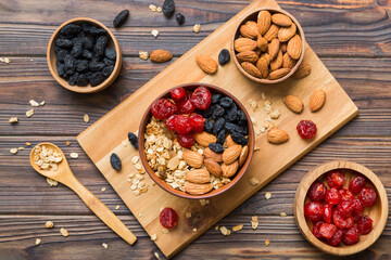 Cooking a wholesome breakfast. Granola with Various dried fruits and nuts in a bowl. The concept of a healthy dessert. Flat lay, top view with copy space