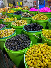 Green and black olives and pink cauliflowers offered at a market in Amman, Jordan