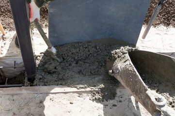 Feeding concrete into the formwork for pouring the foundation.