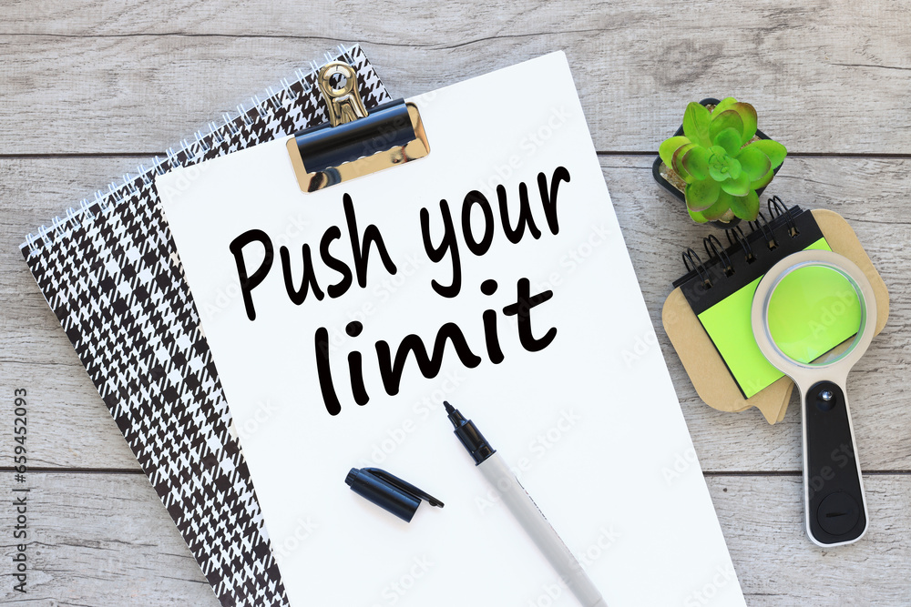 Poster push your limit text on white a4 paper on a beautiful notepad. sticker magnifying glass