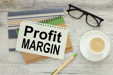 PROFIT MARGIN. paper with text on a notepad near a cup of coffee