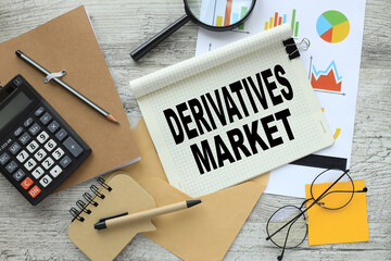 derivatives market. stationery and calculator on financial chart. text on notepad page with spiral