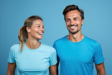 Portrait of two persons wearing casual plain blue t-shirt and smiling. Isolated on a plain colored background. Generative AI.
