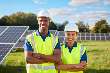 Portrait Of Smiling Male And Female Engineers Inspecting Solar Panels Generating Renewable Energy