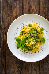 Tagliatelle with basil pesto sauce on wooden table
