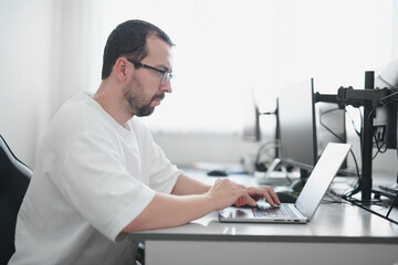 Portrait professional man programmer working concentrated on computer in diverse offices. Modern IT technologies, development artificial intelligence, programs, applications and video games concept.