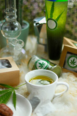 Cannabis Lime Soda Cooling drinks with cannabis as an ingredient are placed on a classic wooden table in glasses decorated with beautiful cannabis leaves. Recreational cannabis concept.