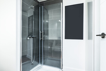 Shower cabin with glass screens in a bathroom with white walls