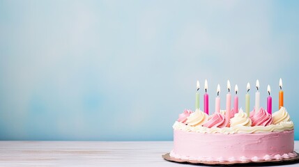 Ein rosa Geburtstagskuchen mit weißem Zuckerguss und bunten, pastellfarbenen, brennenden Kerzen vor hellblauem Hintergrund, mit Platz für Text und Glückwünsche. Geburtstagskarte - obrazy, fototapety, plakaty