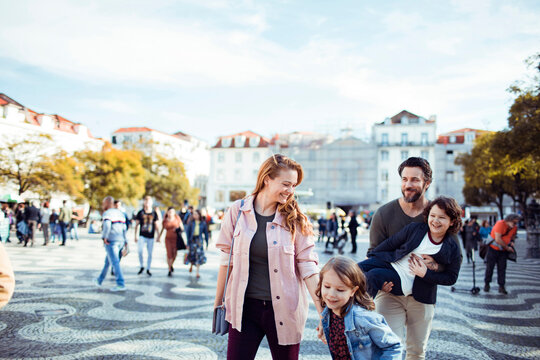 Happy young family exploring the Rossio Square while on vacation in Lisbon