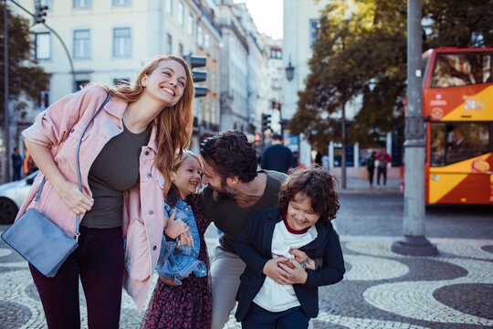 Happy young family exploring the Rossio Square while on vacation in Lisbon