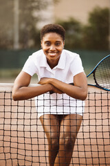 Portrait of a young beautiful women with tennis clothes and racket in a tennis court ready to play a game.