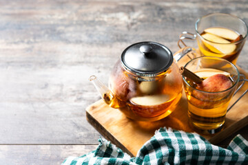 Hot apple drink with spices on wooden table. Copy space