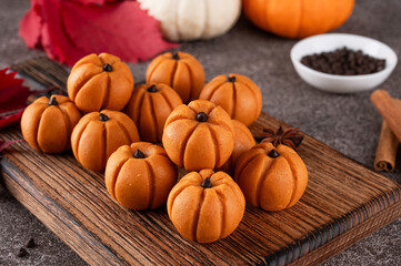 Halloween spicy mini cheesecakes with pumpkin puree in the form of small pumpkins. Halloween or Thanksgiving dessert.