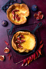 Dutch baby pancake with fresh figs and honey. Fall, autumn breakfast recipe. Pancake in a pan baked in the oven