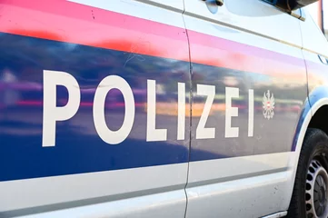 Foto auf Acrylglas Police patrol car parked on the street in Vienna, Austria. Austrian police car on the street. Side view of a police car with the lettering "Polizei".  © Ajdin Kamber