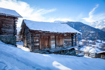 old mountain hut in the snow, in an Swiss Alpine valley