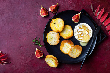 Baked Brie or Camembert cheese with toasted bread and fresh figs. Fall, autumn appetizer platter recipe