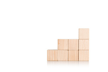 wooden cubes in the form of a ladder with a hand on an isolate white background