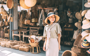 Young adult traveler asian woman travel and shopping at wicker souvenir shop at local street Chiang Mai, Thailand