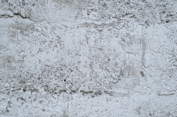 Gray stained concrete wall, dirty cracked uneven cement surface with paint close-up. Photography, abstraction, background.
