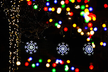 A city Christmas display with lights and snowflakes, with a bokeh effect on the colored lights