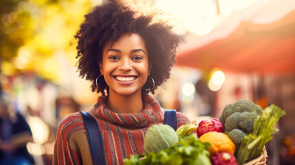 Happy young woman holding basket of fresh products at farmers market