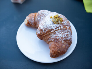 croissant on white plate cornetto pistachio cream, tender and sugary morning breakfast