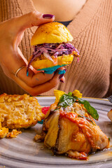 Bun homemade ripieno di pulled pork e insalata coleslaw servito come antipasto e tenuto tra le mani...
