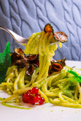 Spaghetti alla Nerano con crema di zucchine, provolone del monaco e zucchine fritte serviti in un...