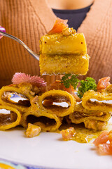 Pasta con crema di pistacchio e tartare di tonno servita in un ristorante elegante e impiattata con decorazione floreale