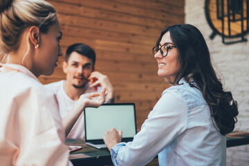 Team of young women and man discussing work questions