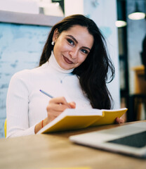 Smiling woman taking notes in notebook