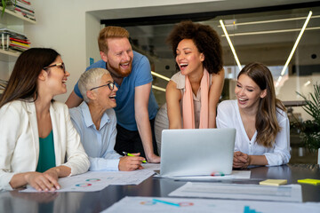 Smiling diverse colleagues gather in boardroom brainstorm discuss financial statistics together